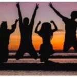 silhouette for students jumping at sunset