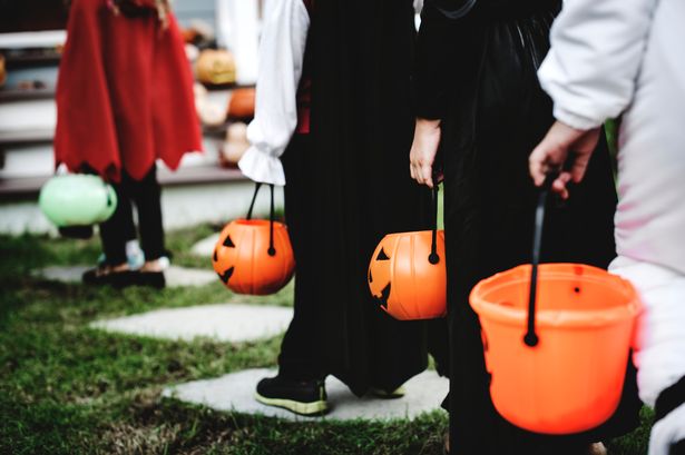 children trick or treating with pumpkin baskets