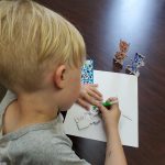 young boy coloring a picture