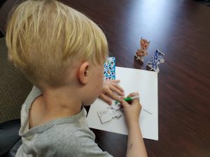 young boy coloring a picture