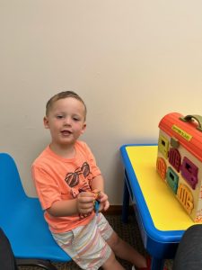child in speech therapy playing with a toy with keys
