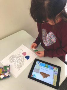 child in therapy putting stickers on a page