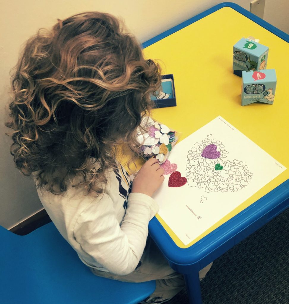 girl in therapy putting stickers on a page