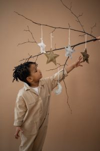 child touching tree ornaments