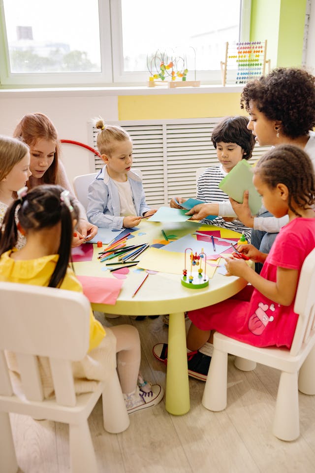 children working with teachers at a table